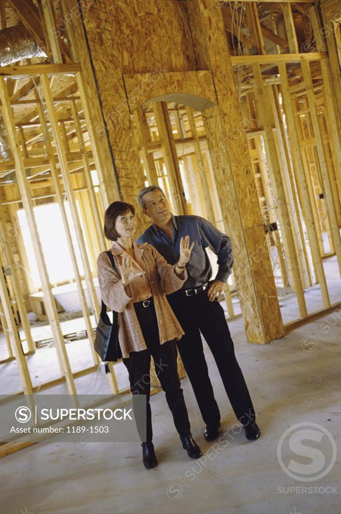 Stock Photo: 1189-1503 Mature couple standing in a house being built