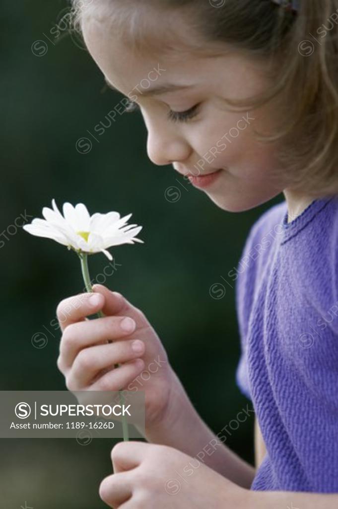 Stock Photo: 1189-1626D Side profile of a girl holding a flower
