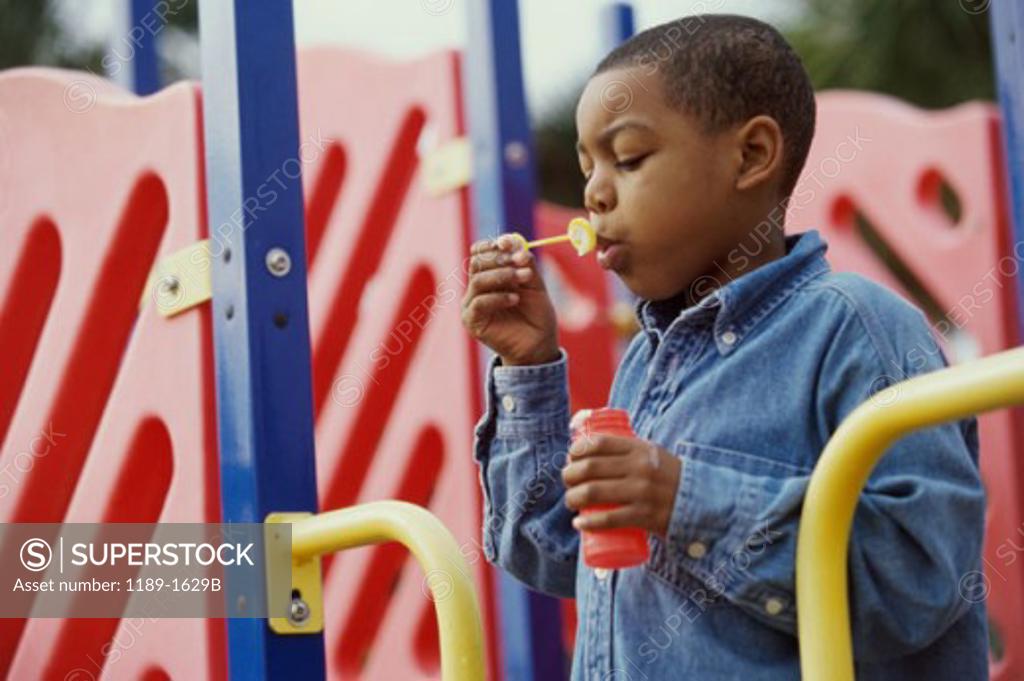 Stock Photo: 1189-1629B Boy playing with a bubble wand