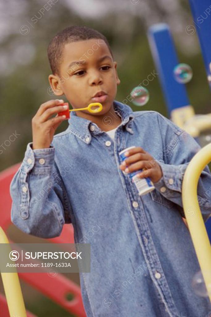Stock Photo: 1189-1633A Close-up of a boy blowing bubbles with a bubble wand