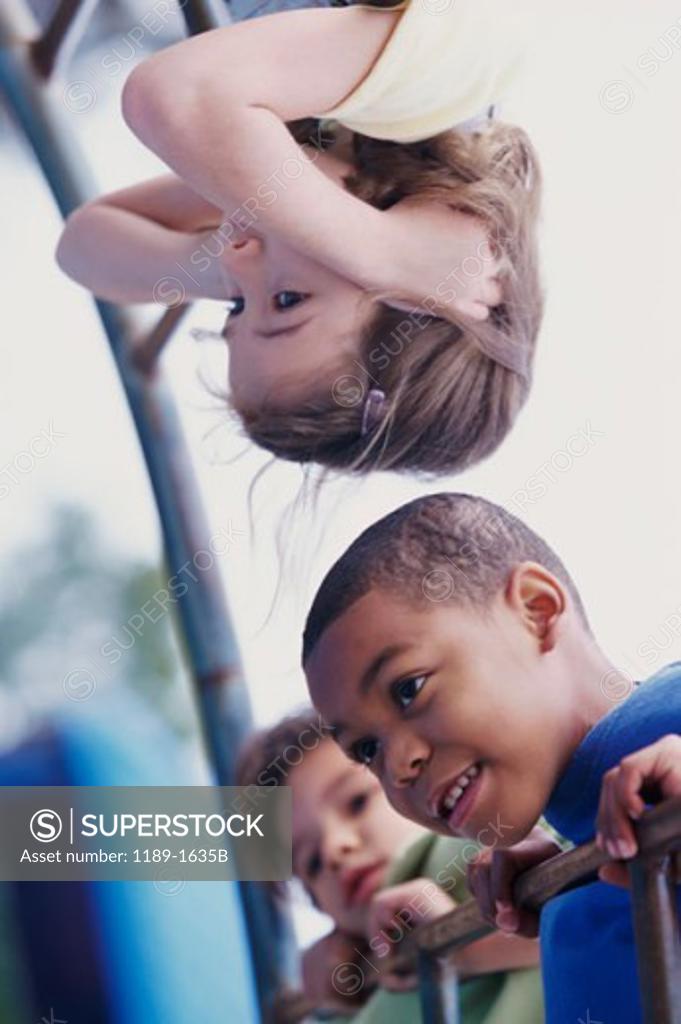 Stock Photo: 1189-1635B Two boys and a girl playing on monkey bars
