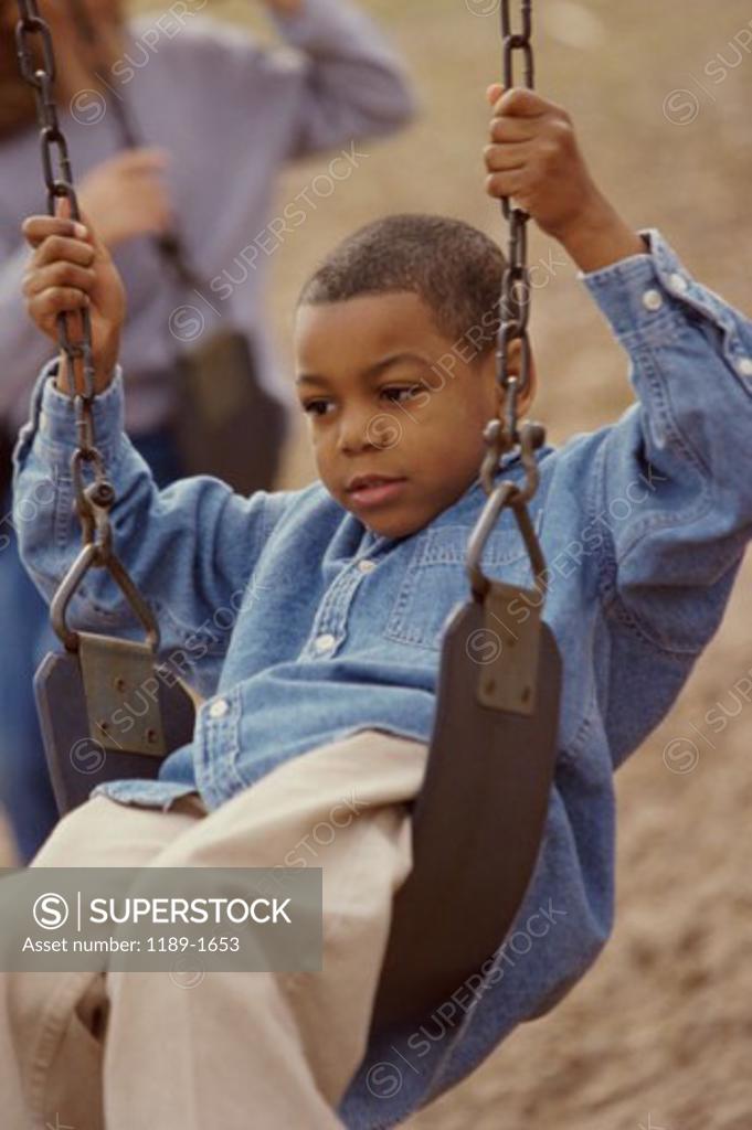 Stock Photo: 1189-1653 Close-up of a boy swinging on a swing