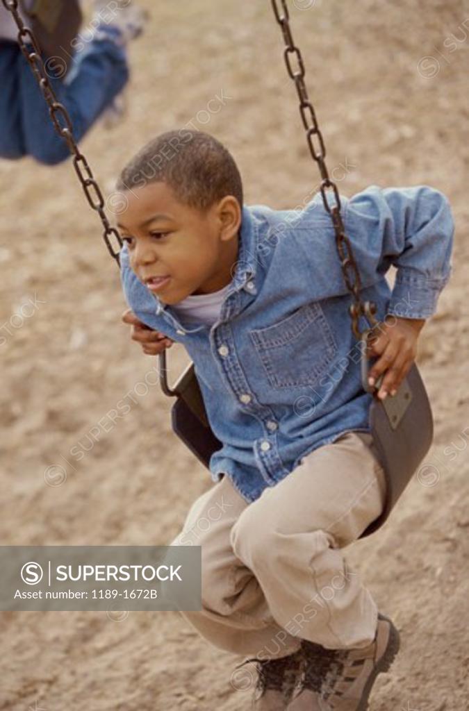 Stock Photo: 1189-1672B Boy swinging on a chain swing