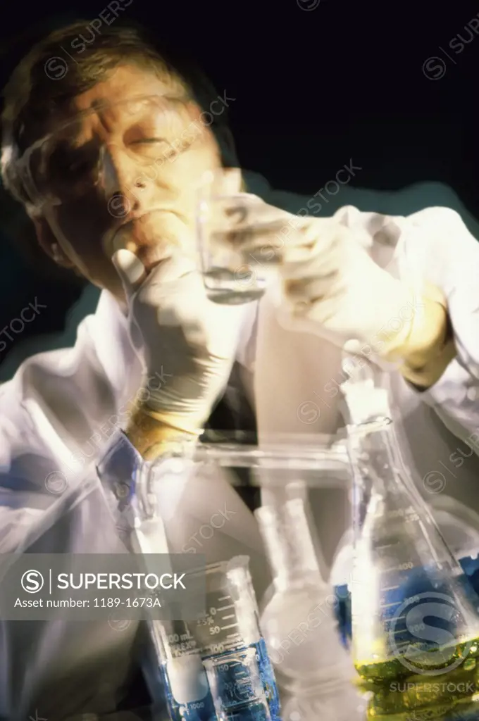 Male scientist looking at a beaker in a laboratory