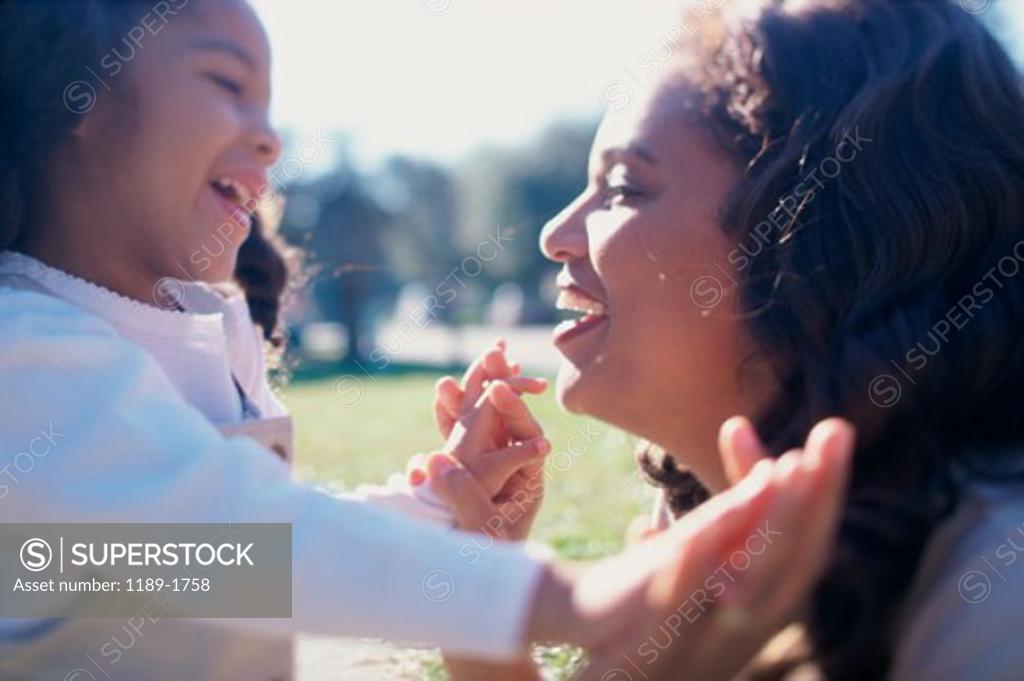 Stock Photo: 1189-1758 Side profile of a mother playing with her daughter