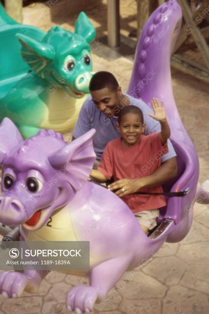 Stock Photo: 1189-1839A Father with his son on a ride in an amusement park