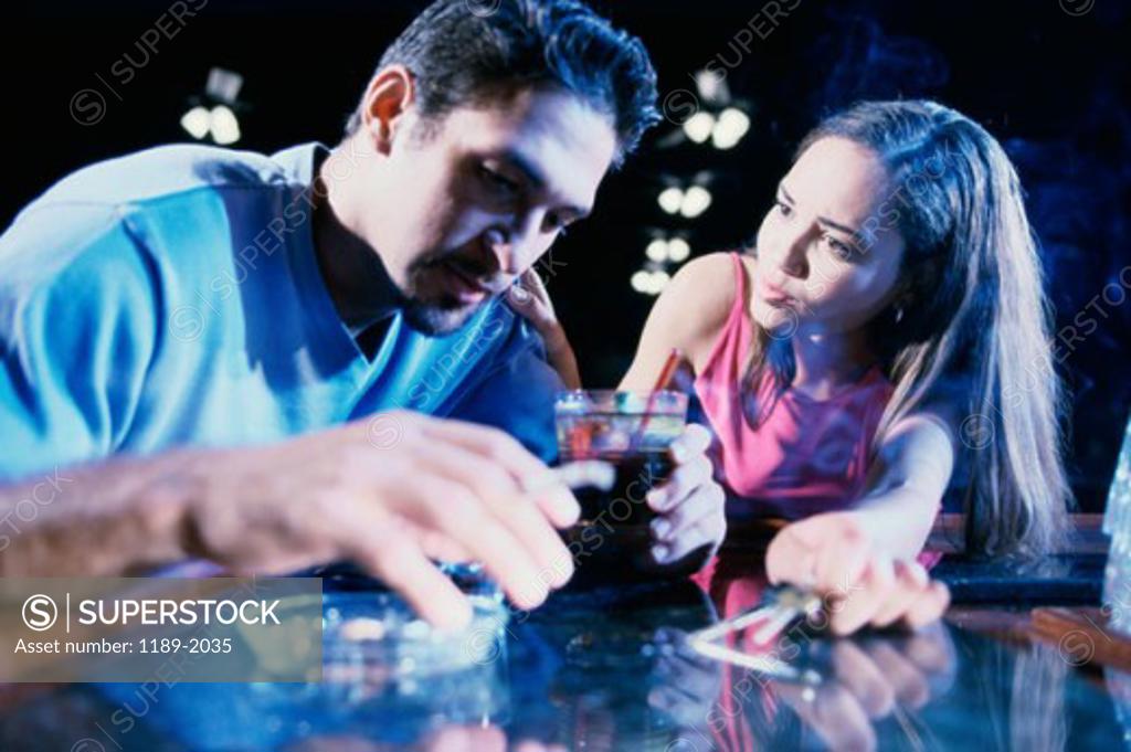 Stock Photo: 1189-2035 Close-up of a young man drinking wine with a young woman looking at him