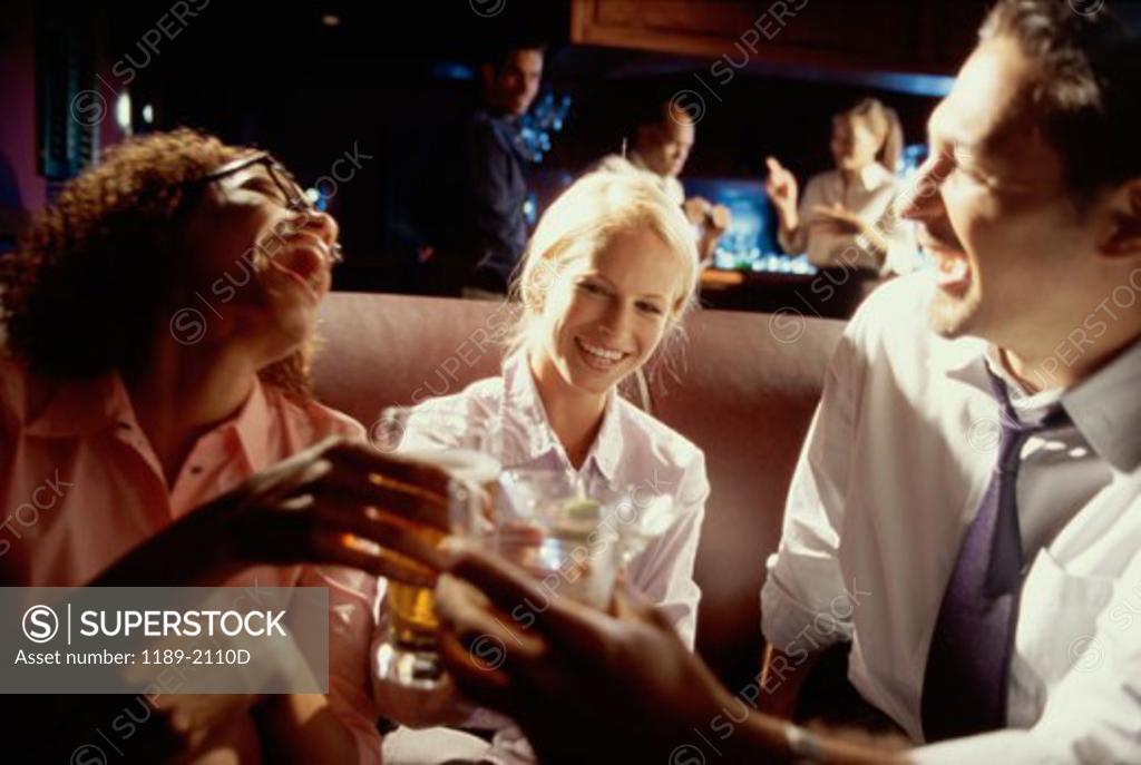 Stock Photo: 1189-2110D Young man with his friends toasting and laughing in a bar