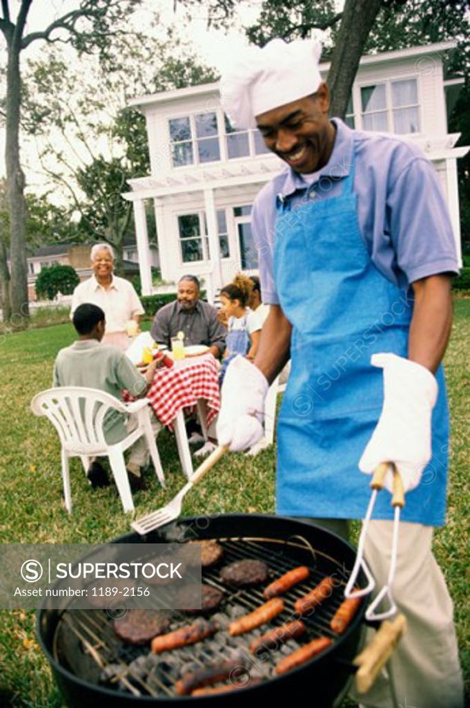 Stock Photo: 1189-2156 Mid adult man barbecuing on a grill