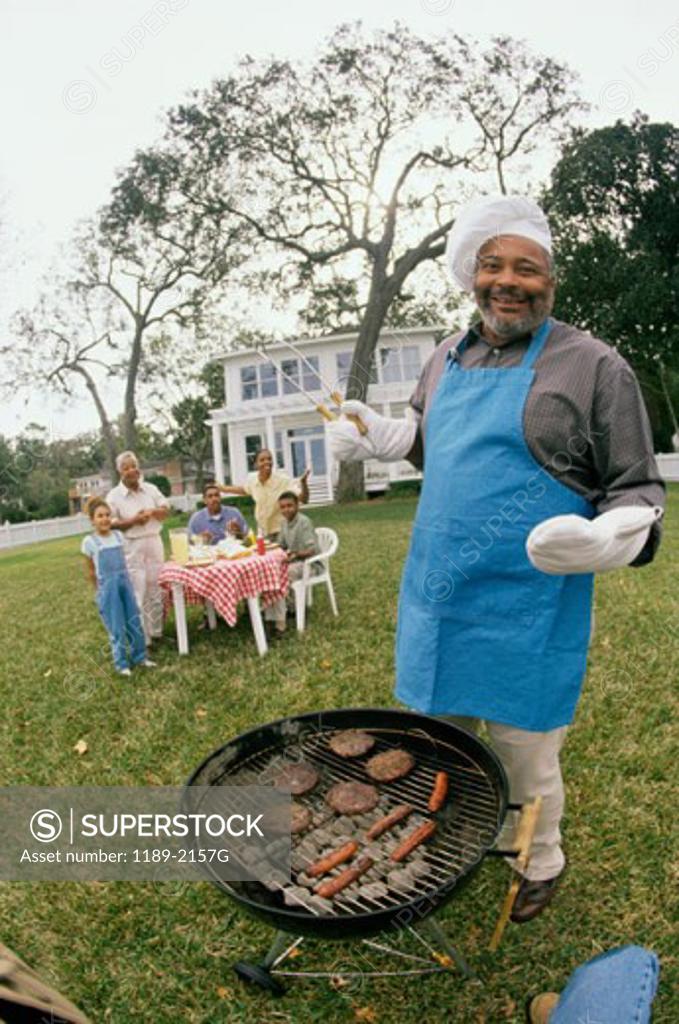 Stock Photo: 1189-2157G Senior man cooking at a barbecue grill