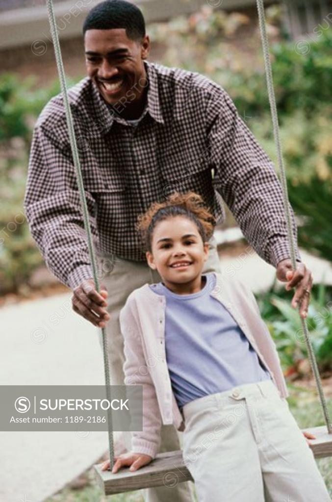 Stock Photo: 1189-2186 Father pushing his daughter on a swing