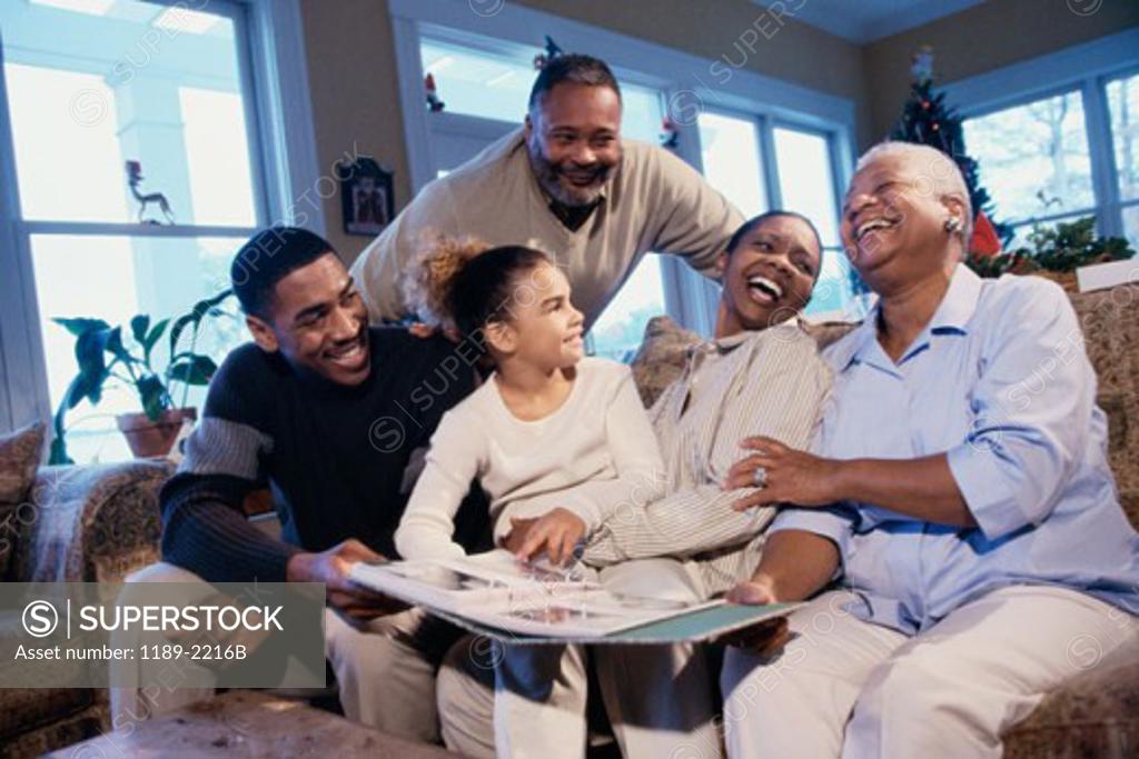 Stock Photo: 1189-2216B Family sitting together and looking at a photo album