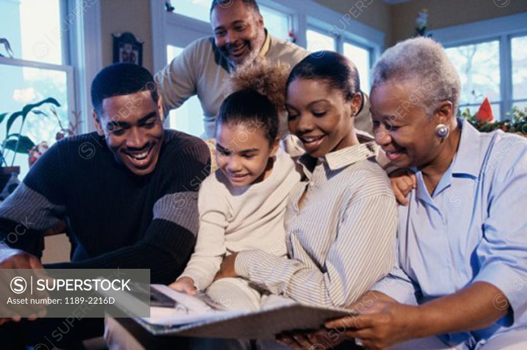 Stock Photo: 1189-2216D Family sitting together and looking at a photo album