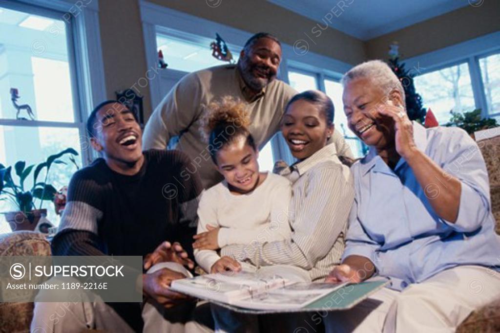 Stock Photo: 1189-2216E Family sitting together and looking at a photo album