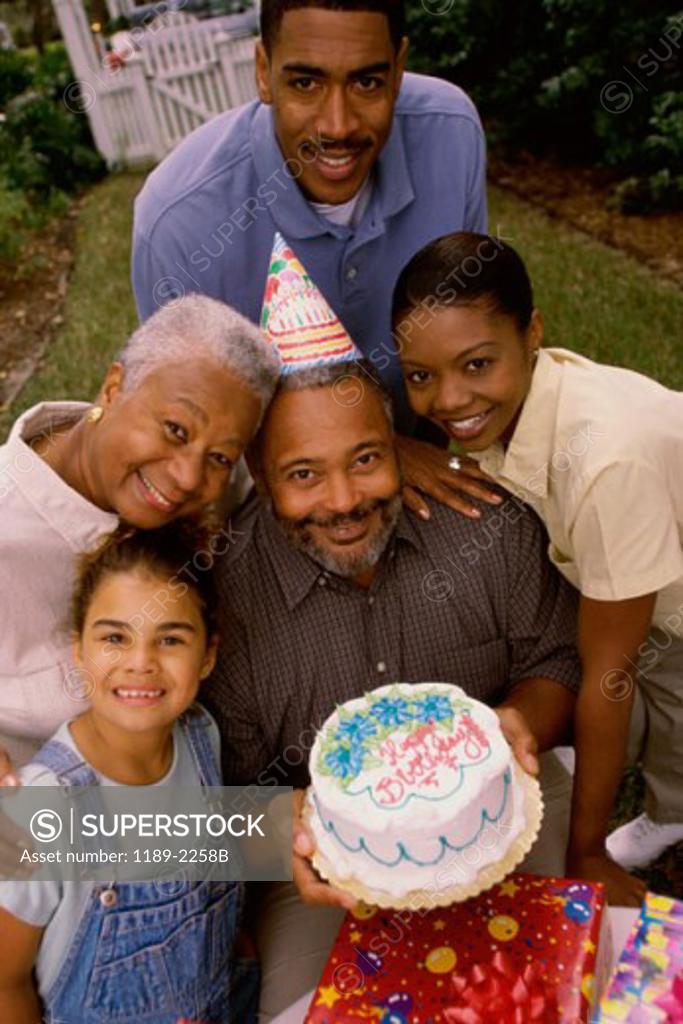Stock Photo: 1189-2258B High angle view of a senior man holding a birthday cake with his family members