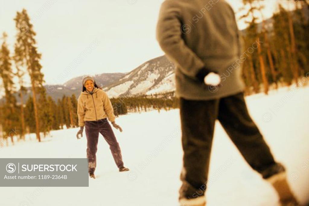 Stock Photo: 1189-2364B Young couple playing with snowballs in snow
