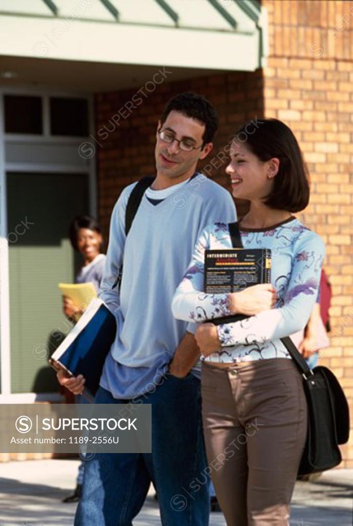 Stock Photo: 1189-2556U Young man and a young woman walking on a college campus