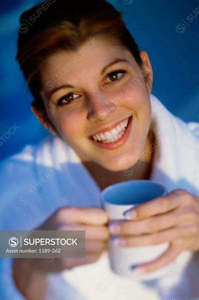 Stock Photo: 1189-262 Portrait of a young woman holding a cup of coffee