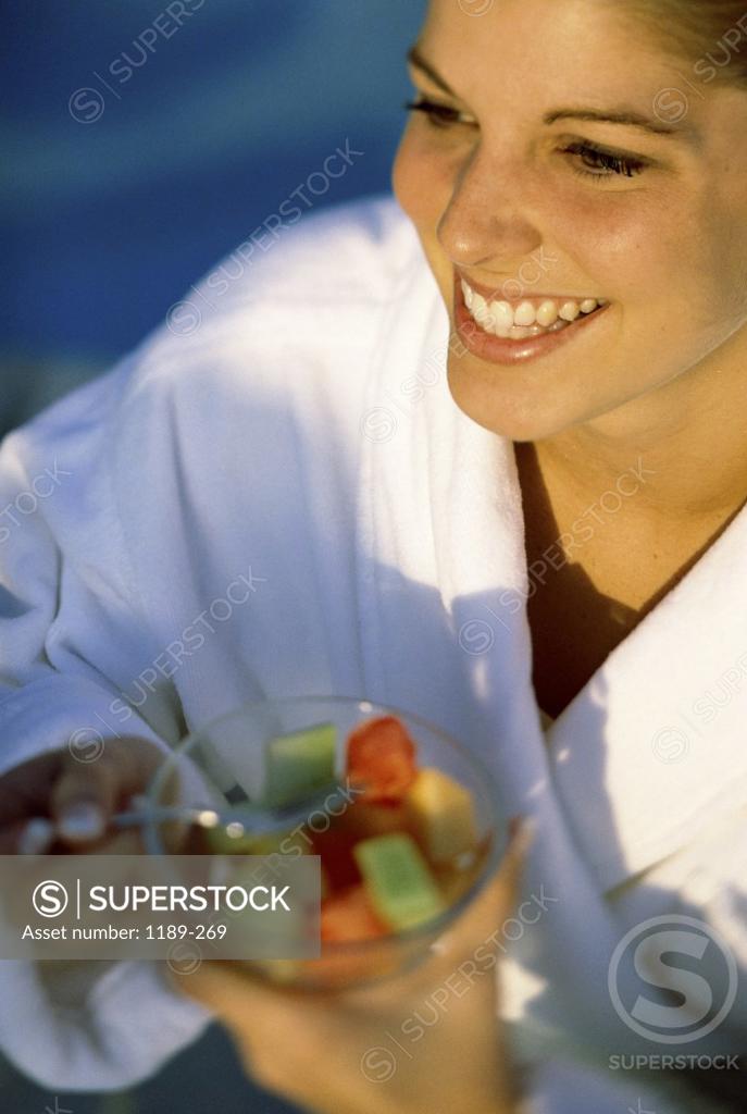 Stock Photo: 1189-269 Young woman holding a bowl of fruit