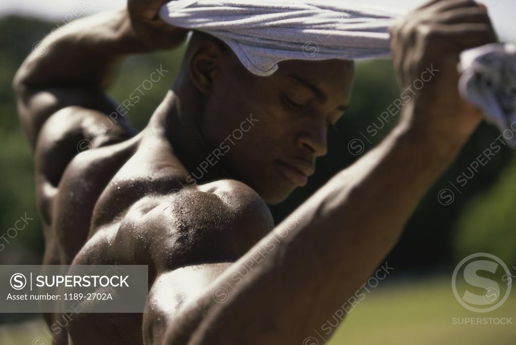 Stock Photo: 1189-2702A Side profile of a young man flexing his muscles