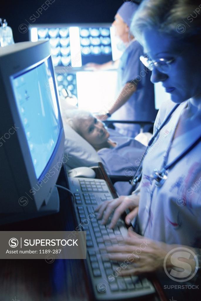 Stock Photo: 1189-287 Side profile of a female nurse operating a computer
