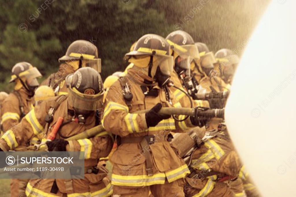 Stock Photo: 1189-3049B Group of firefighters spraying water with a fire hose