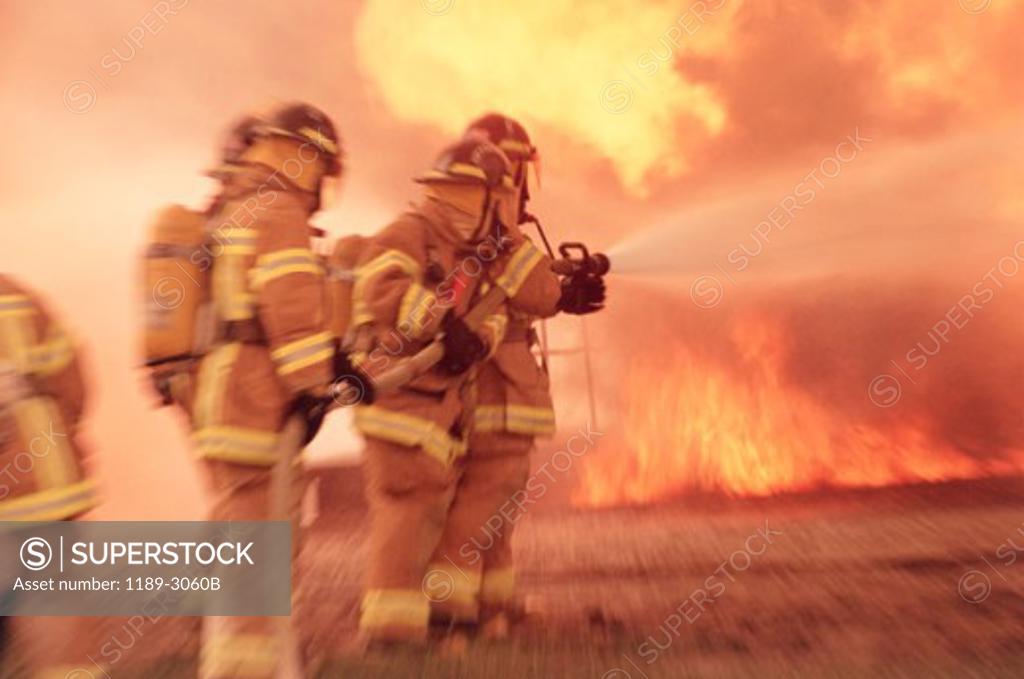 Stock Photo: 1189-3060B Group of firefighters spraying water with a fire hose