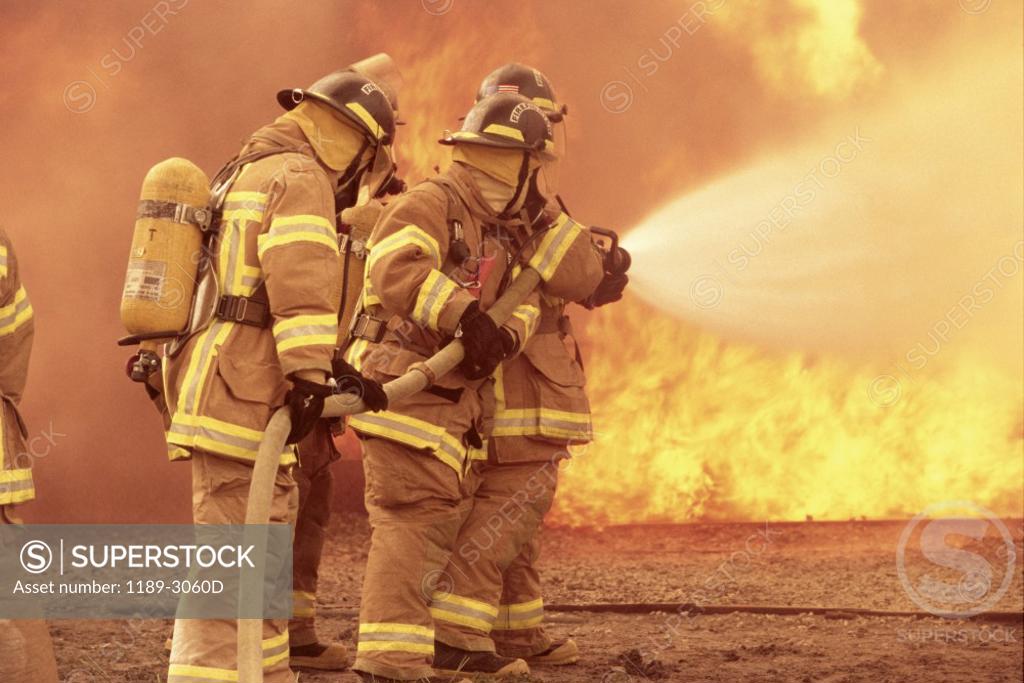 Stock Photo: 1189-3060D Side profile of a group of firefighters holding water hoses
