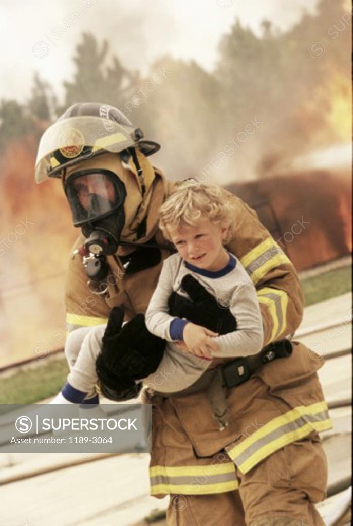 Stock Photo: 1189-3064 Firefighter carrying a boy