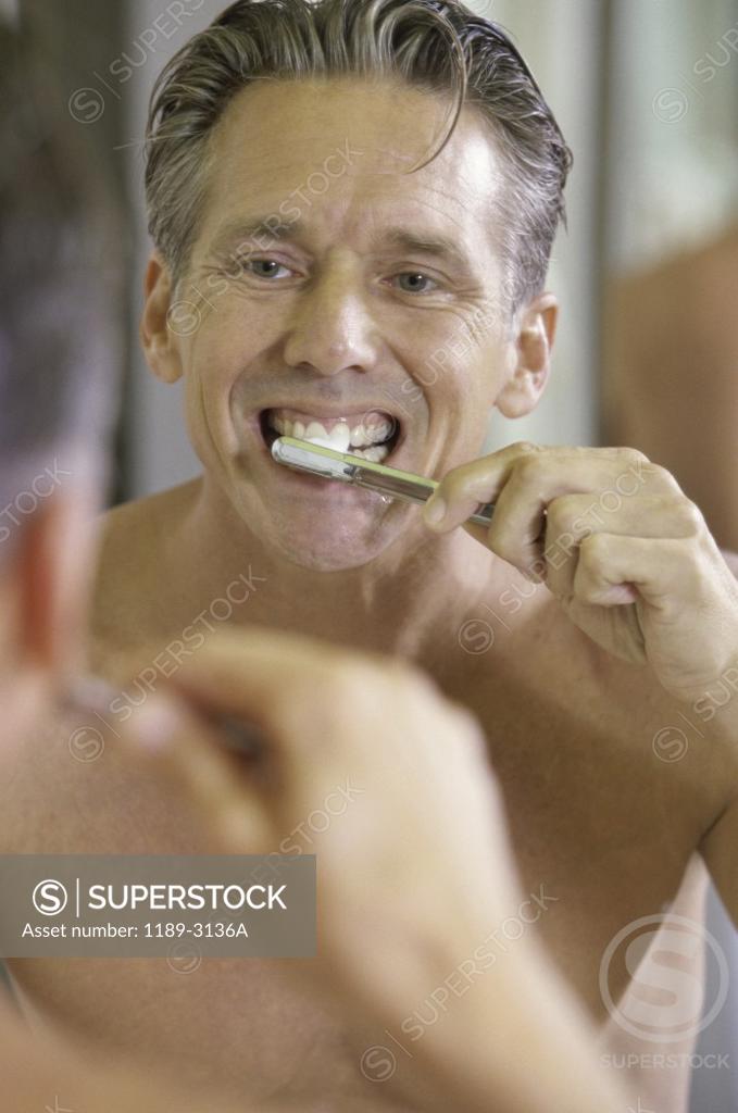 Stock Photo: 1189-3136A Mid adult man brushing his teeth