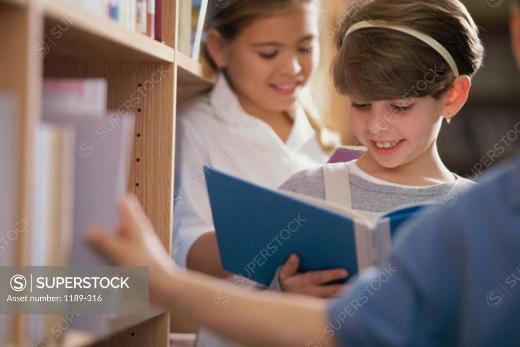 Stock Photo: 1189-316 Two girls reading books in a library