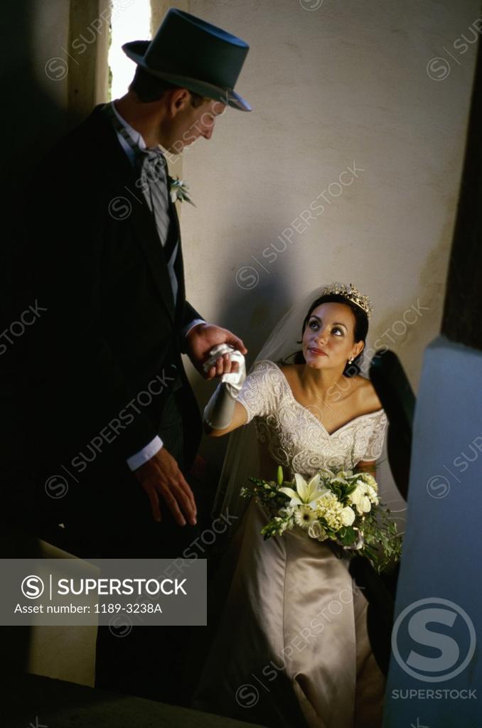 Stock Photo: 1189-3238A High angle view of a groom holding his bride's hand on a staircase