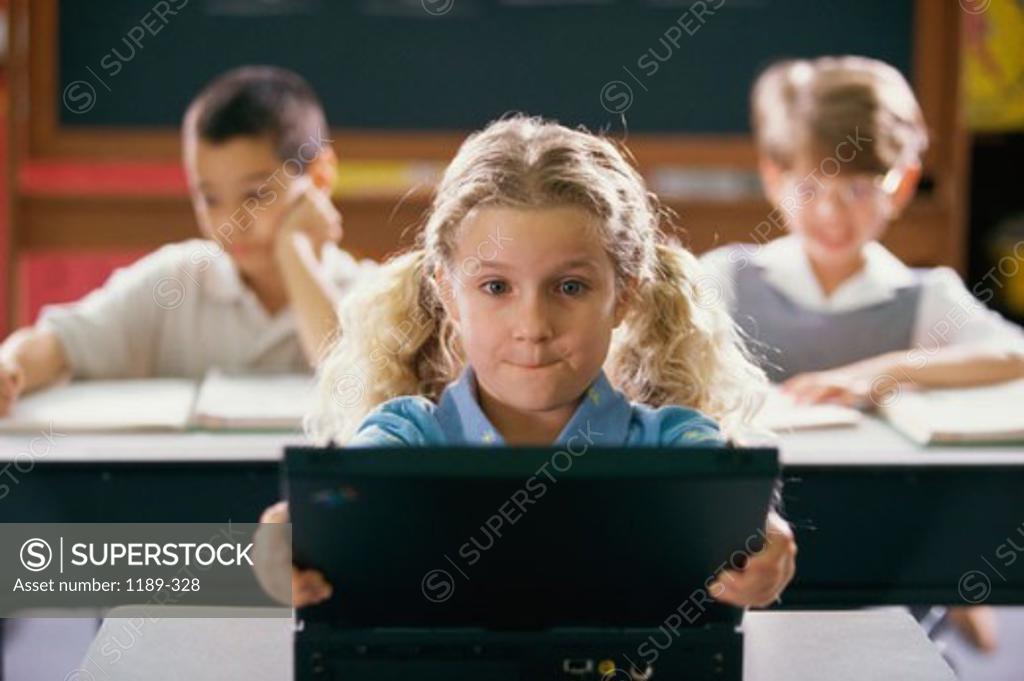 Stock Photo: 1189-328 Girl using a laptop in a classroom