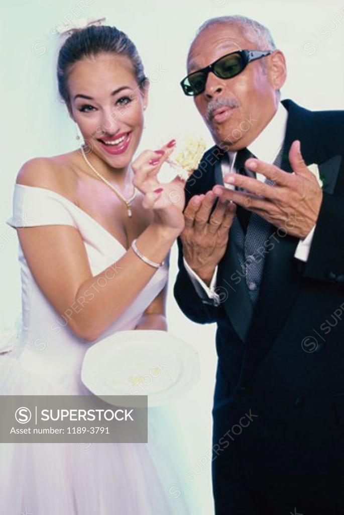 Stock Photo: 1189-3791 Portrait of a bride feeding cake to her groom