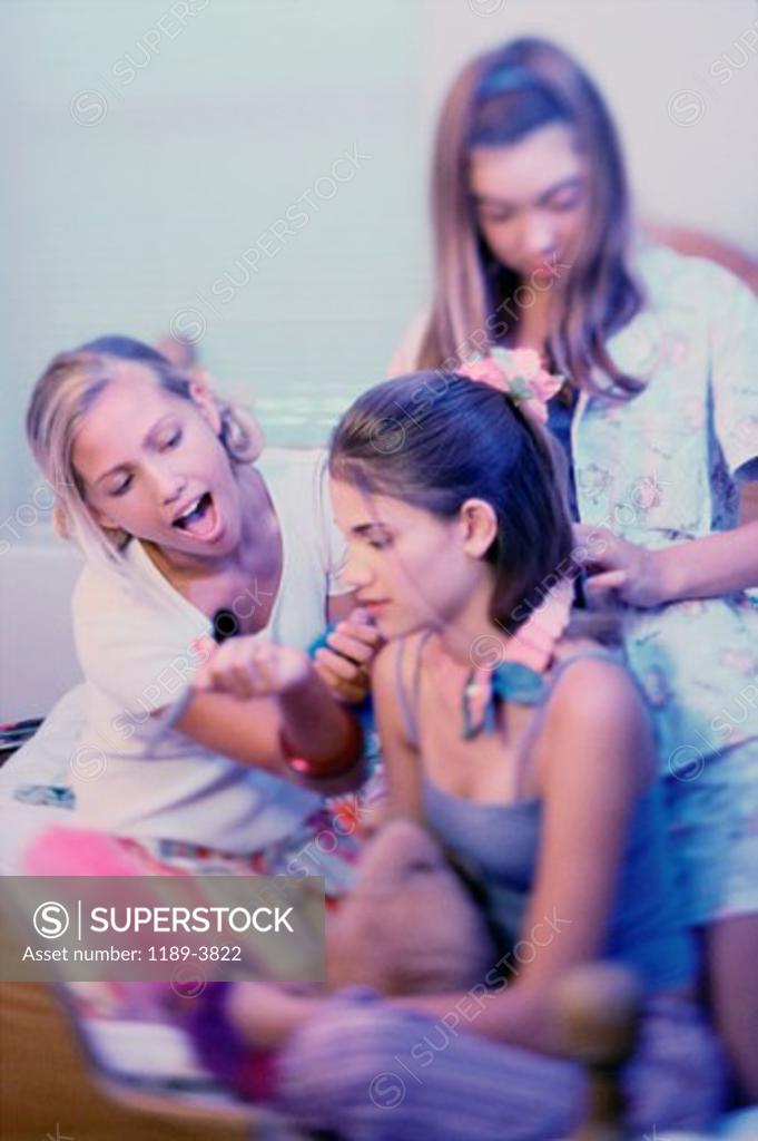 Stock Photo: 1189-3822 Two teenage girls dressing up their friend