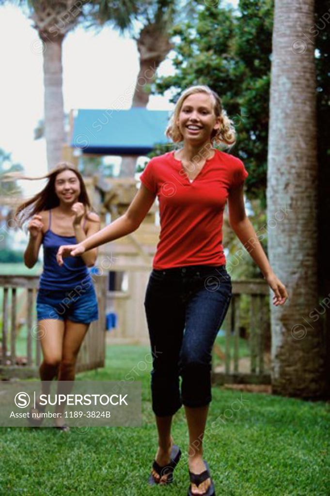 Stock Photo: 1189-3824B Two teenage girls running in a park