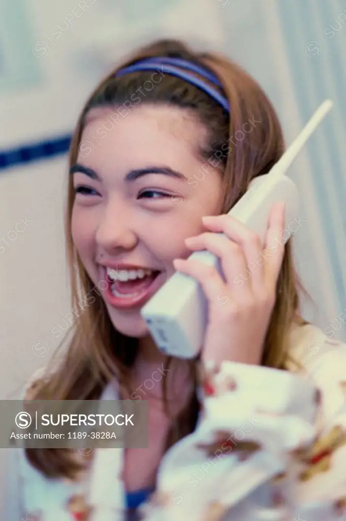 Close-up of a teenage girl talking on a cordless phone