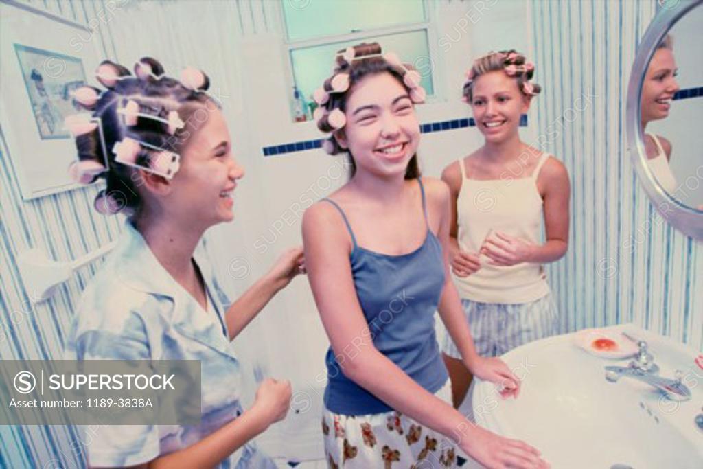 Stock Photo: 1189-3838A Three teenage girls wearing hair curlers