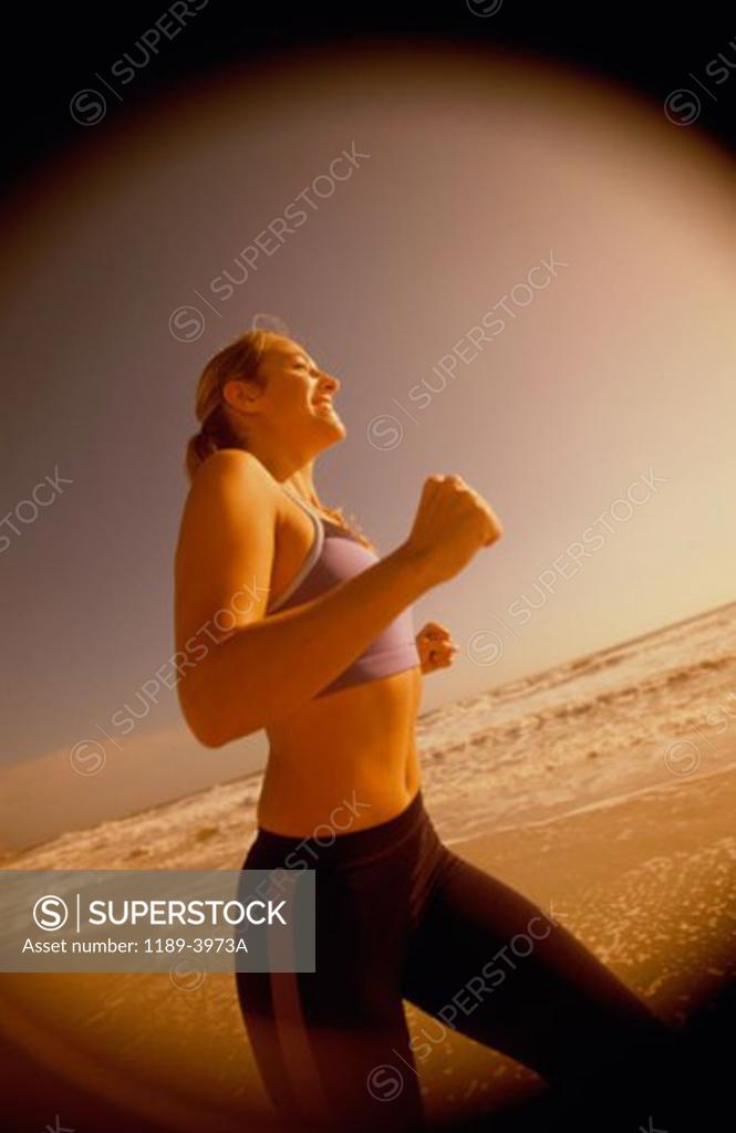 Stock Photo: 1189-3973A Side profile of a young woman jogging on the beach