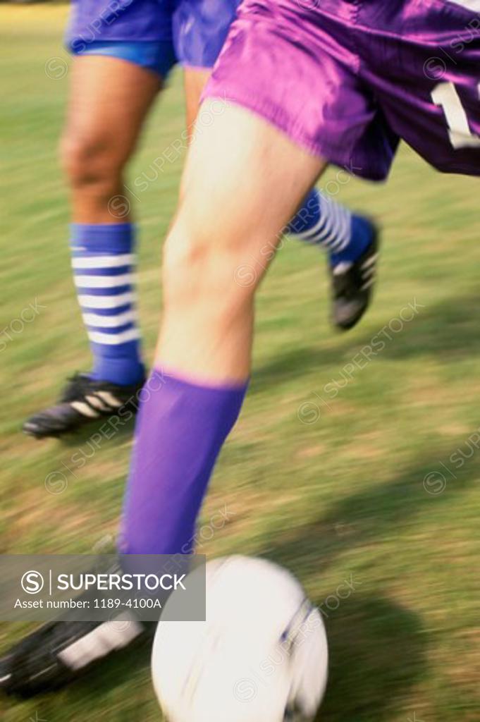 Stock Photo: 1189-4100A Low section view of two soccer players playing with a soccer ball