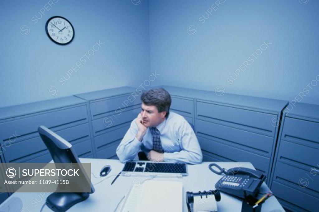 Stock Photo: 1189-4115B High angle view of a businessman sitting in front of a computer monitor