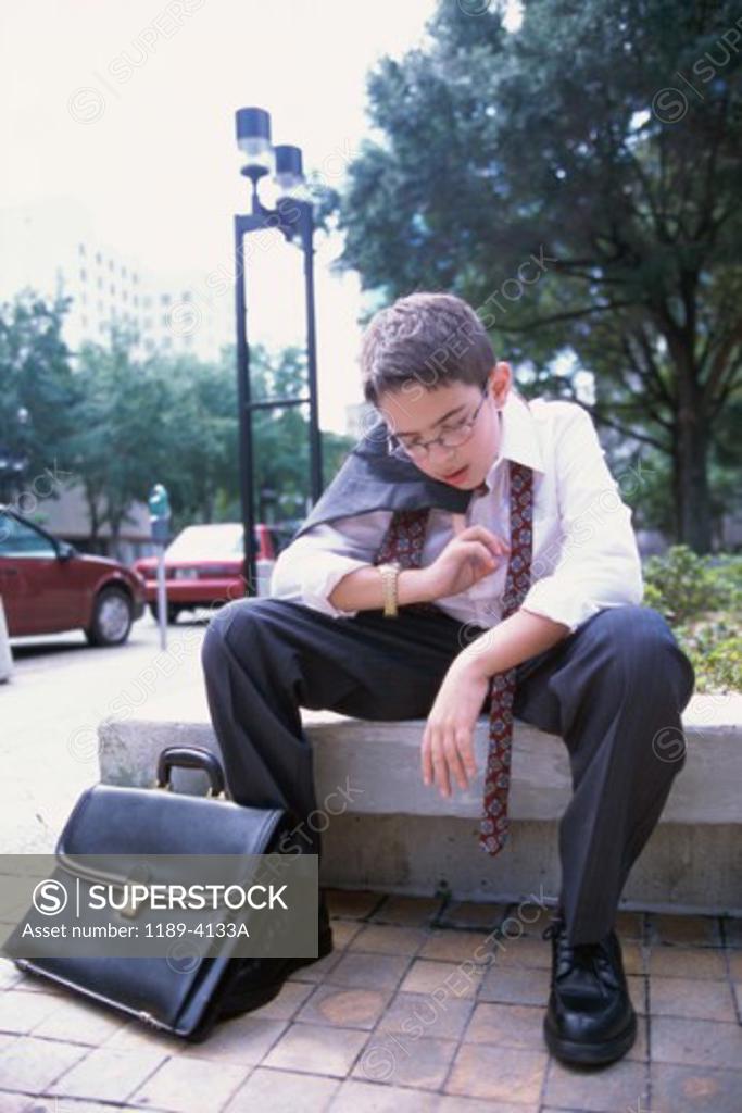 Stock Photo: 1189-4133A Boy wearing a business suit resting
