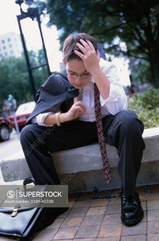 Stock Photo: 1189-4133B Boy wearing a business suit resting
