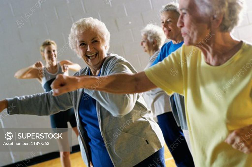 Stock Photo: 1189-562 Young woman teaching a group of senior women aerobics