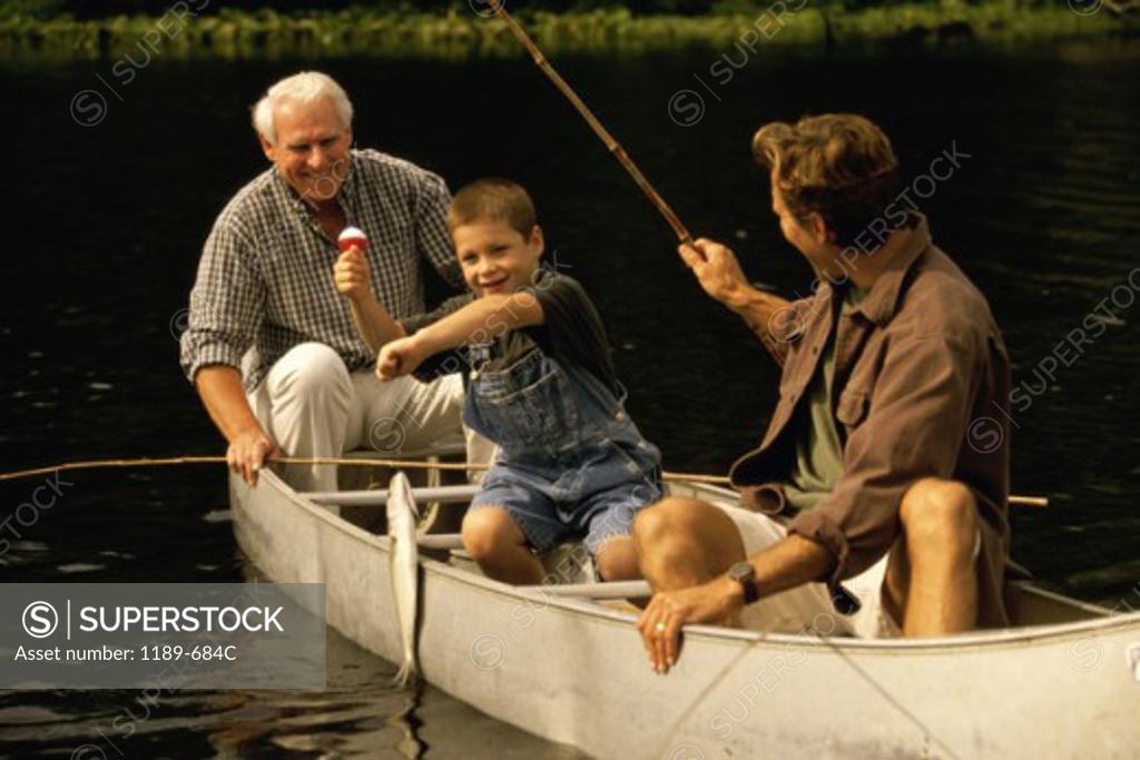 Stock Photo: 1189-684C Grandfather sitting in a boat with his son and grandson
