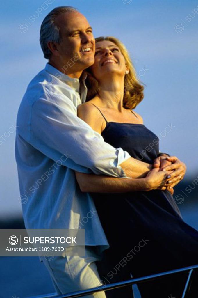 Stock Photo: 1189-768D Senior man embracing a senior woman from behind and smiling