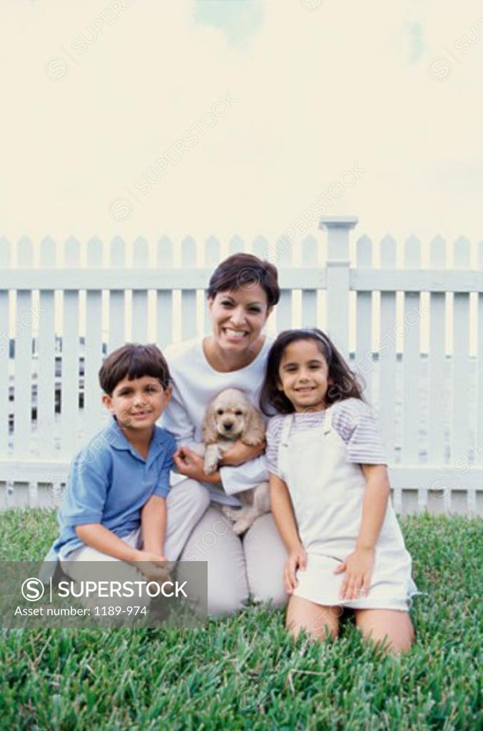 Stock Photo: 1189-974 Portrait of a mother holding a puppy smiling with her two children