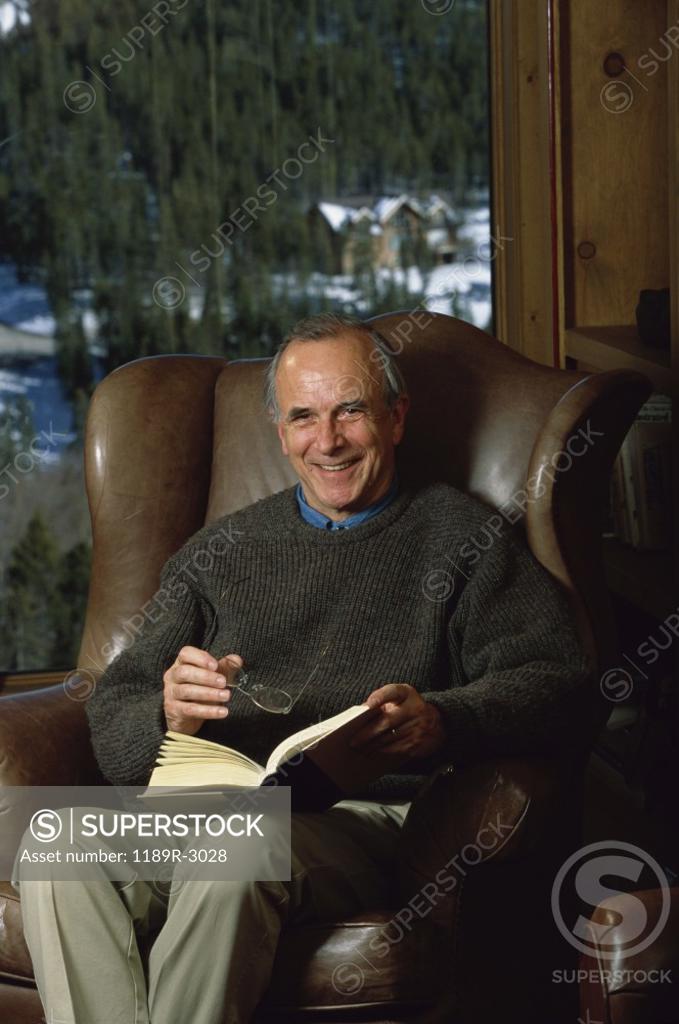 Stock Photo: 1189R-3028 Portrait of a senior man holding a book