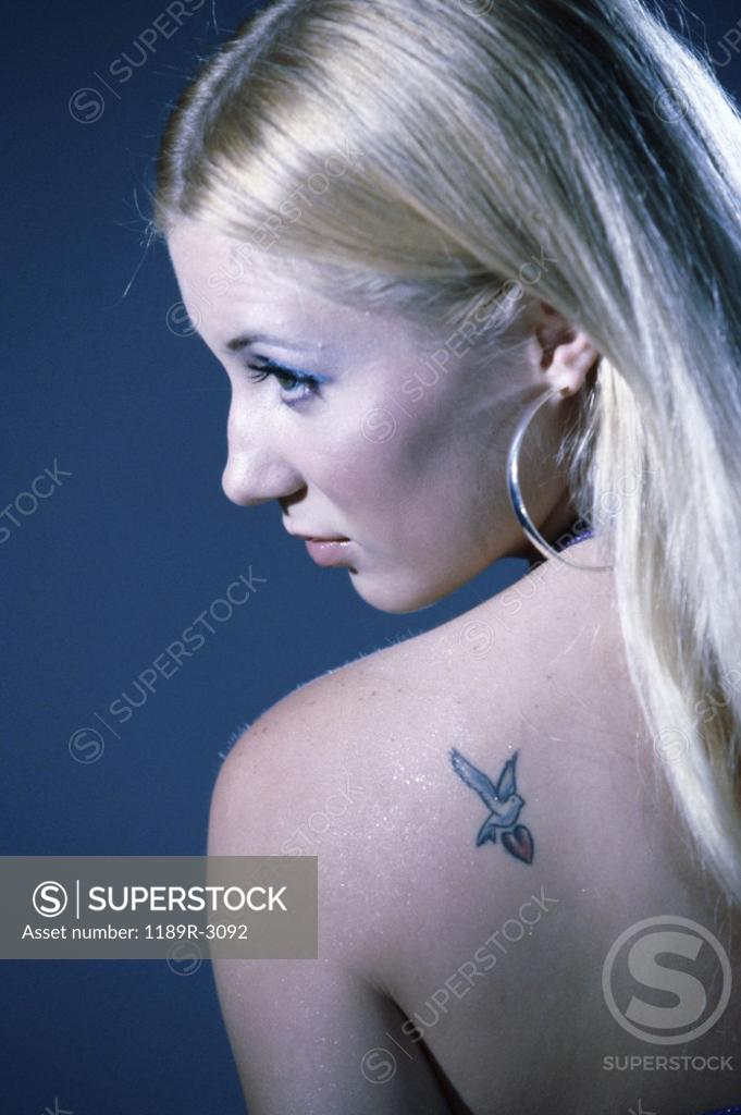 Stock Photo: 1189R-3092 Rear view of a young woman with a tattoo on her shoulder