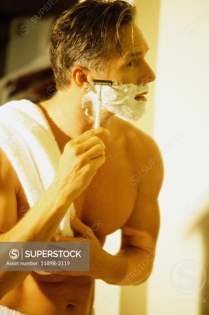 Stock Photo: 1189R-3119 Side profile of a mid adult man shaving